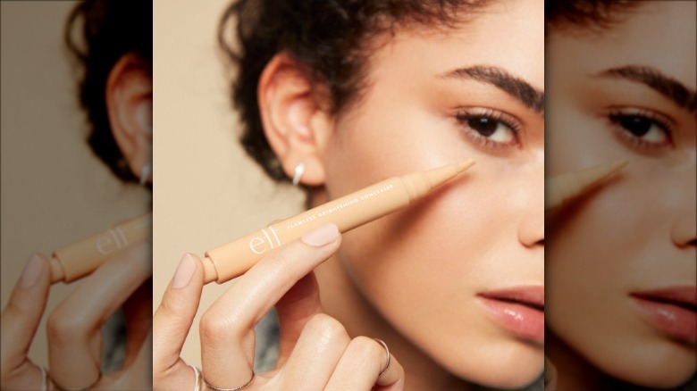 model applies concealer