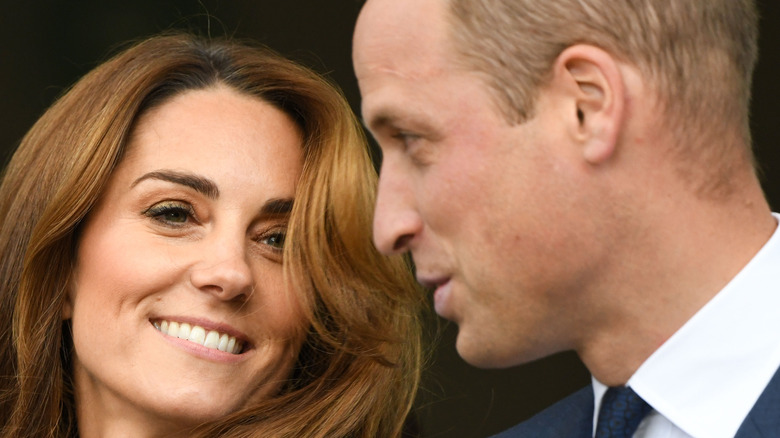 Kate Middleton smiling while Prince William talks