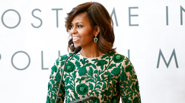Michelle Obama smiling at a podium