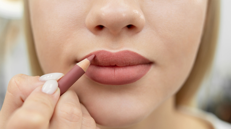 Applying mauve lip liner