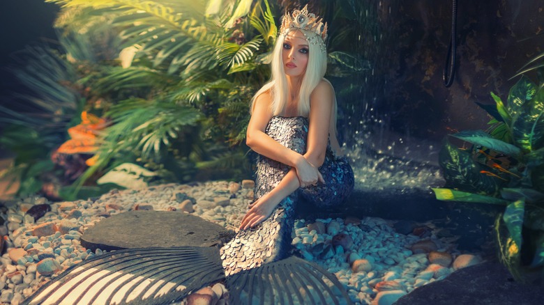 blonde woman wearing mermaid tail and shell crown