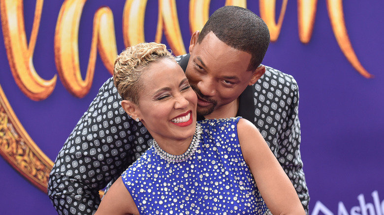 Will Smith and Jada Pinkett Smith smiling and embracing at the premiere of Aladdin in 2019.
