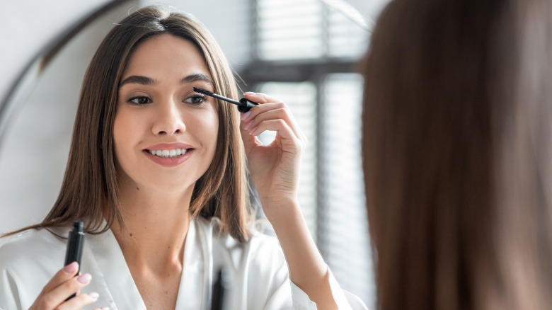 woman putting on mascara