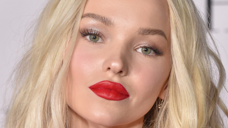 Dove Cameron wearing red lipstick and posing for a picture