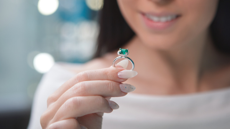 woman holding an emerald ring