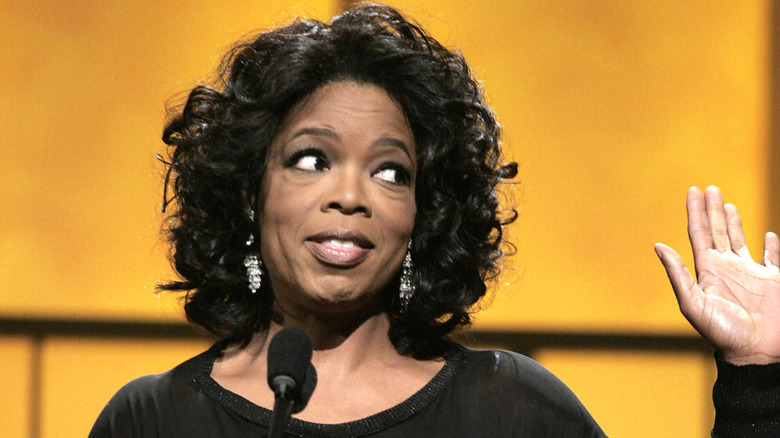 Oprah Winfrey with hand raised