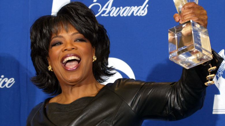 Oprah Winfrey smiling and holding award