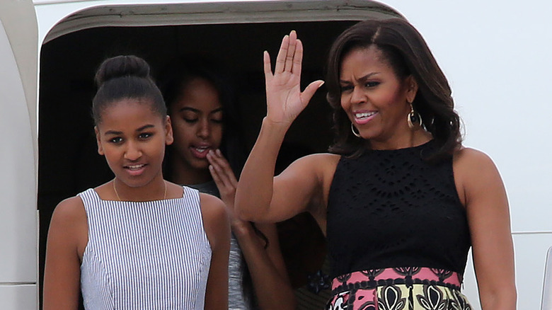 Michelle Obama waving next to daughter Sasha