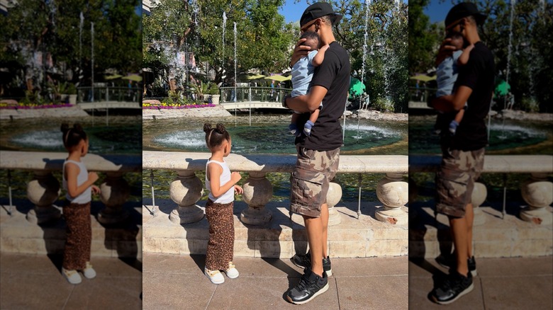 "The Middle" actor  Alphonso McAuley holds his infant son outside by a water fountain next to his daughter