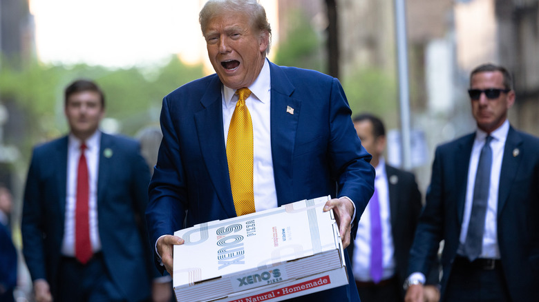 Donald Trump carrying pizza boxes