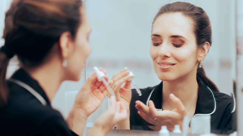 Woman applying facial serum