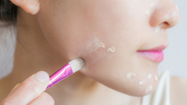 Woman applying concealer 