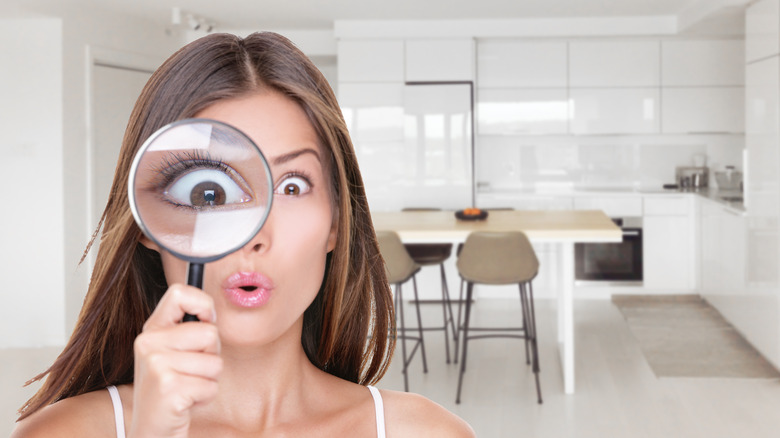 Woman with magnifying glass inspecting home
