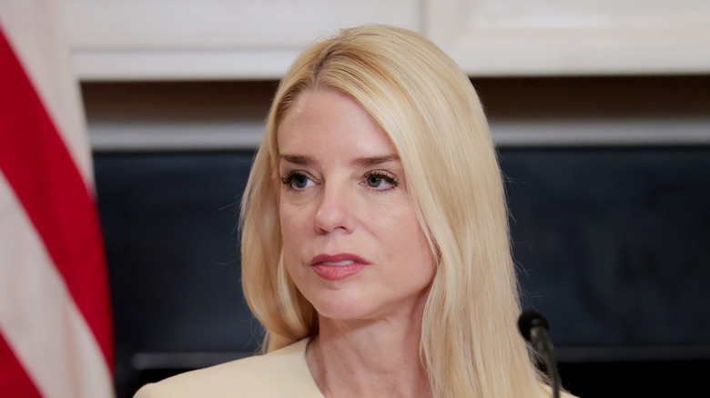 Pam Bondi looking displeased in a cream top