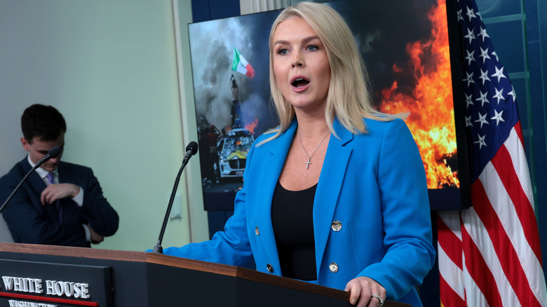 Karoline Leavitt speaking animatedly to the press in a blue blazer