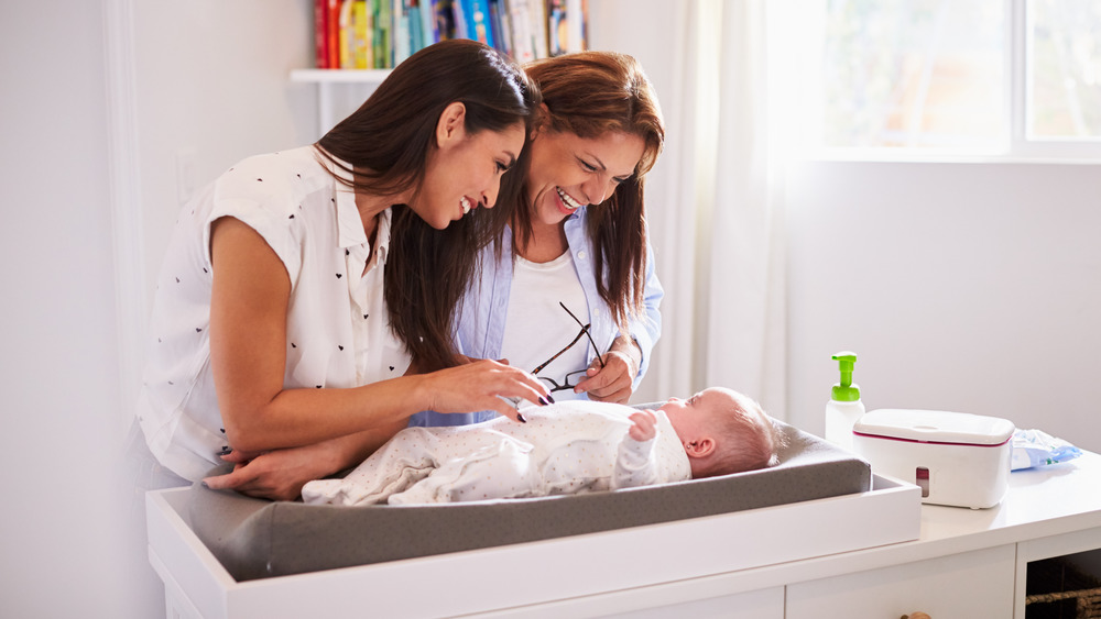 New mom and grandmother look at new baby