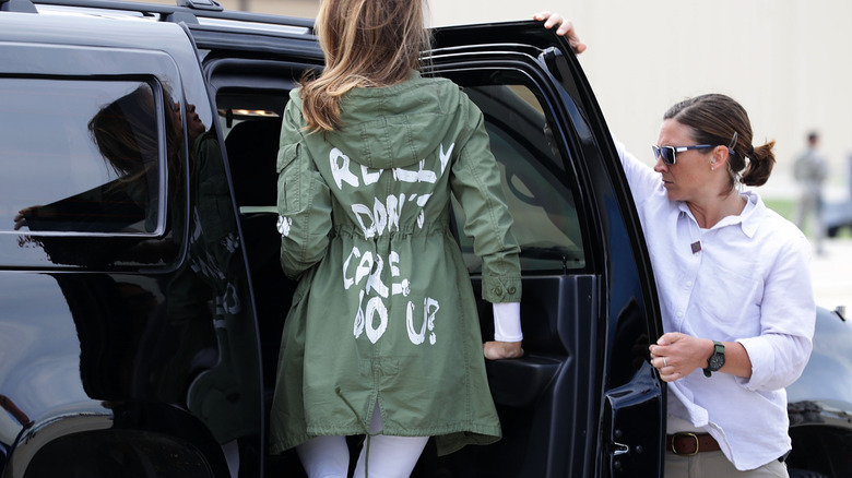 Melania Trump jumps into a black car wearing a green jacket that reads 'I really don't care do u?'