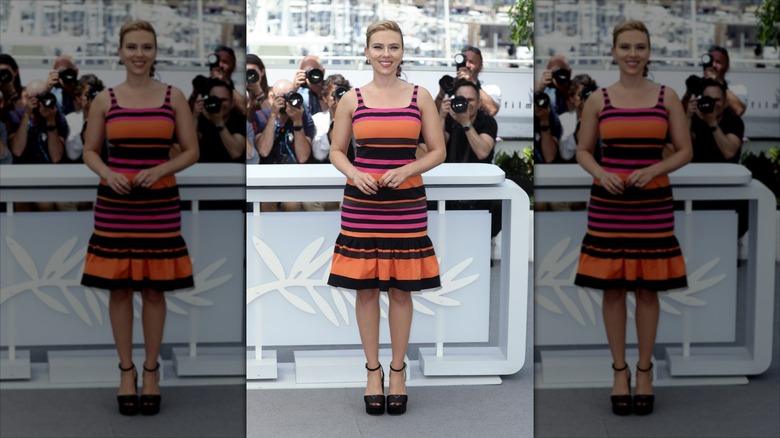 Scarlett Johansson with press behind her in a striped dress.