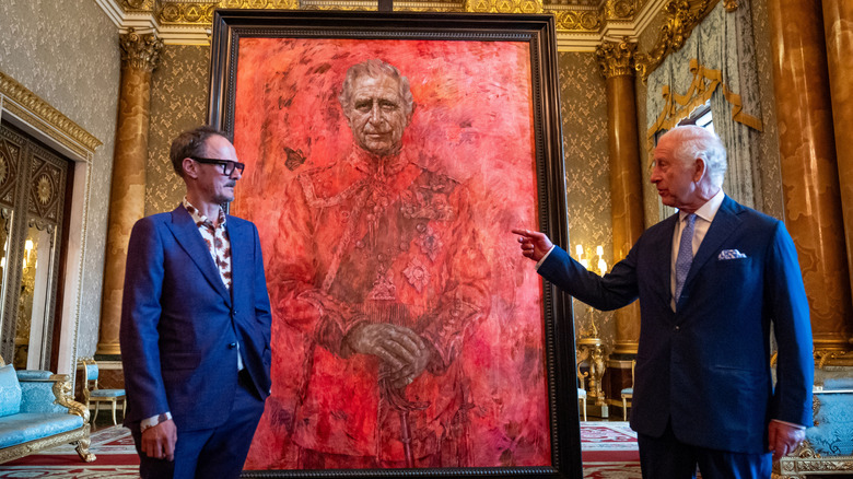 King Charles III and artist Jonathan Yeo chatting next to a portrait of Charles