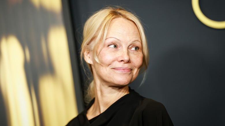 Pamela Anderson without makeup looking over her shoulder.