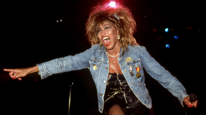Tina Turner performing in the '80s in a denim jacket.