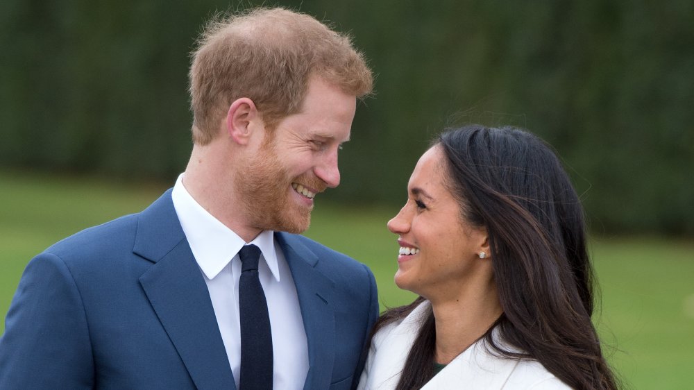 Prince Harry and Meghan Markle grinning at each other