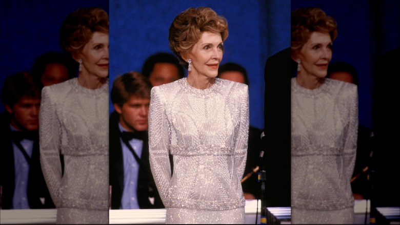 First Lady Nancy Reagan listens to his husband President Ronald Reagan as he addressses the crowd at one of their Inaugural balls after he was sworn in for a second term today (1985)