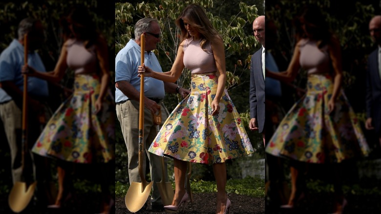 Melania Trump wearing a yellow floral-print skirt and pink high heels during a 2018 tree planting ceremony