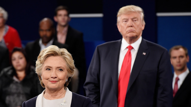 Donald Trump ominously lurking behind a smiling Hillary Clinton
