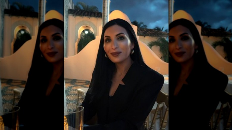 Laura Loomer smiling and sitting at a table for an outdoors picture