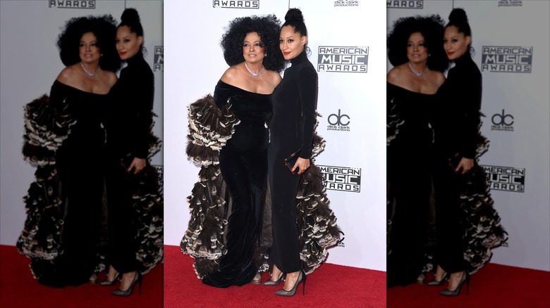 Tracee Ellis Ross and Diana Ross in black floor length dresses posing for paparazzi on the red carpet of the American Music Awards