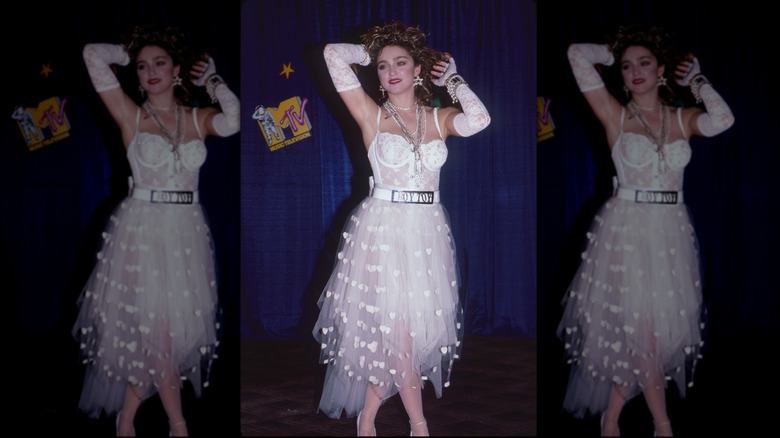 Madonna in white tulle gown with lace bodice, gloves, and a boy toy belt