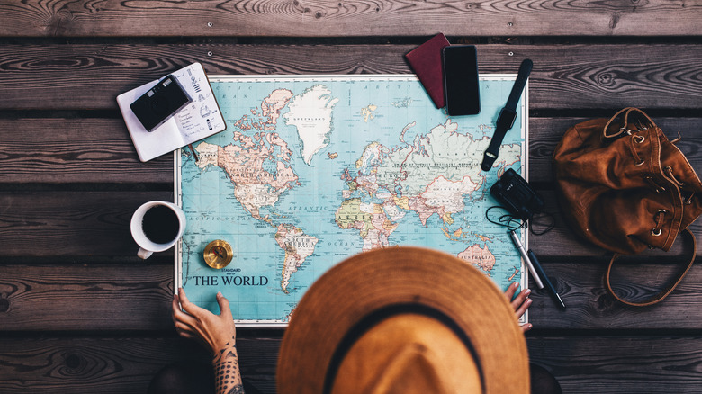 Overhead shot of someone wearing a hat with a map laid out on the table