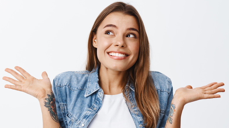 Woman shrugging her arms while smiling