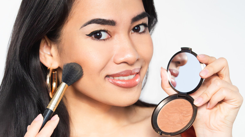 Woman applying bronzer