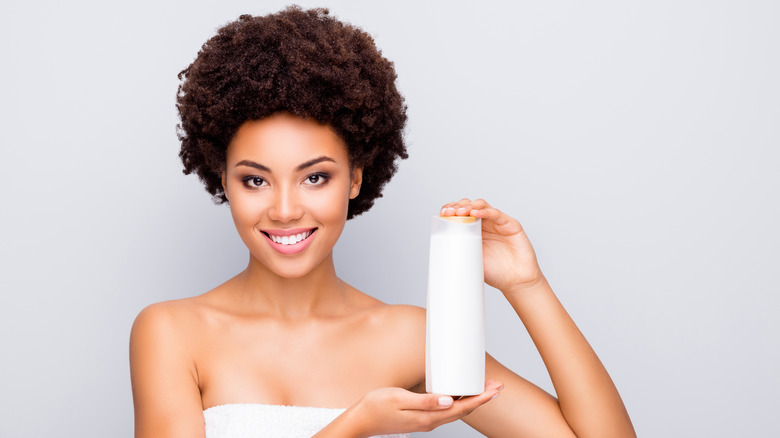 Woman holding shampoo bottle