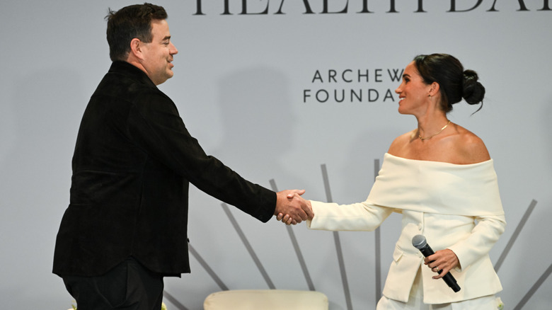 Meghan Markle smiling and shaking hands