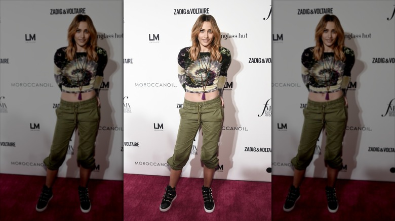 Paris Jackson in a cargo pant and tie dye top with her hands in her back pockets.