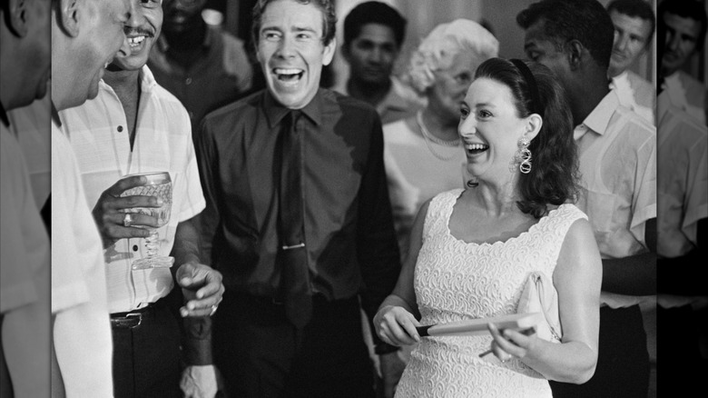 Guests laughing at a party in 1968