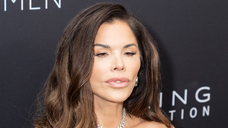 Lauren Sanchez's eyes barely open in front of a black background.