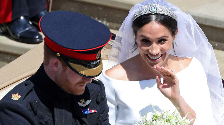 Prince Harry and Meghan Markle riding in a carriage during their wedding