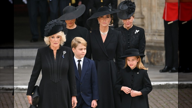 Camilla, Queen Consort, Meghan, Duchess of Sussex, Prince George of Wales, Catherine, Princess of Wales, Princess Charlotte of Wales and Sophie, Countess of Wessex walking together during Queen Elizabeth II's funeral