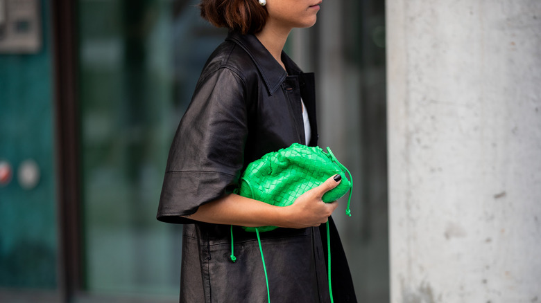 Desirée Kastull with kelly green bag, white dress, and brown coat at Copenhagen Fashion Week 