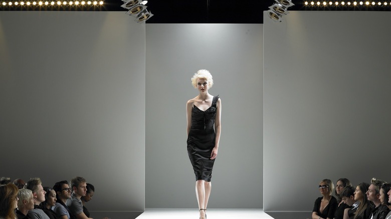 Blond model in black dress on runway