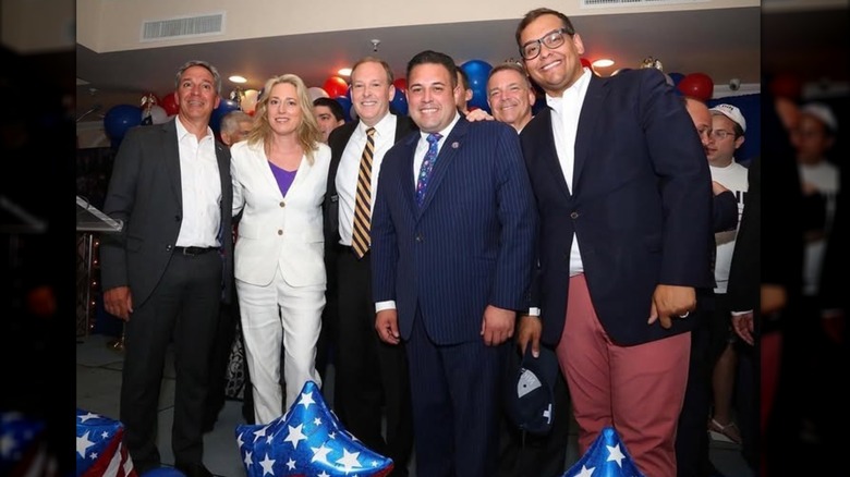 George Santos smiling with a group of people