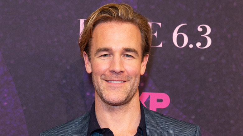 James Van Der Beek poses in a black suit.