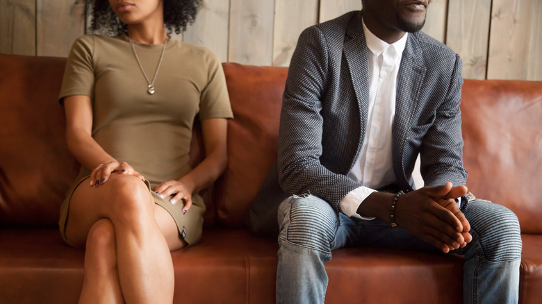 Couple sitting on couch after quarrel