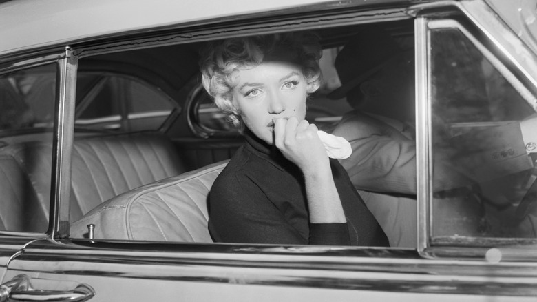 Marilyn Monroe being driven in a car
