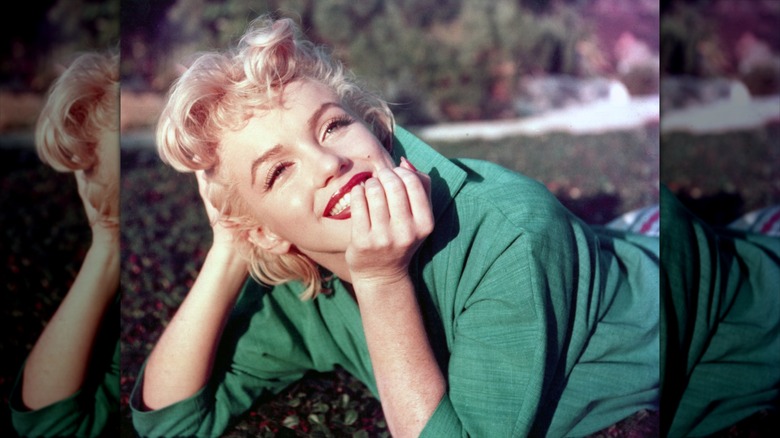 Marilyn Monroe posing for a photo in the grass