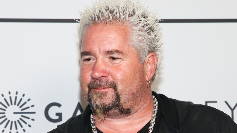 Guy Fieri smiling slightly with bleached spiky hair